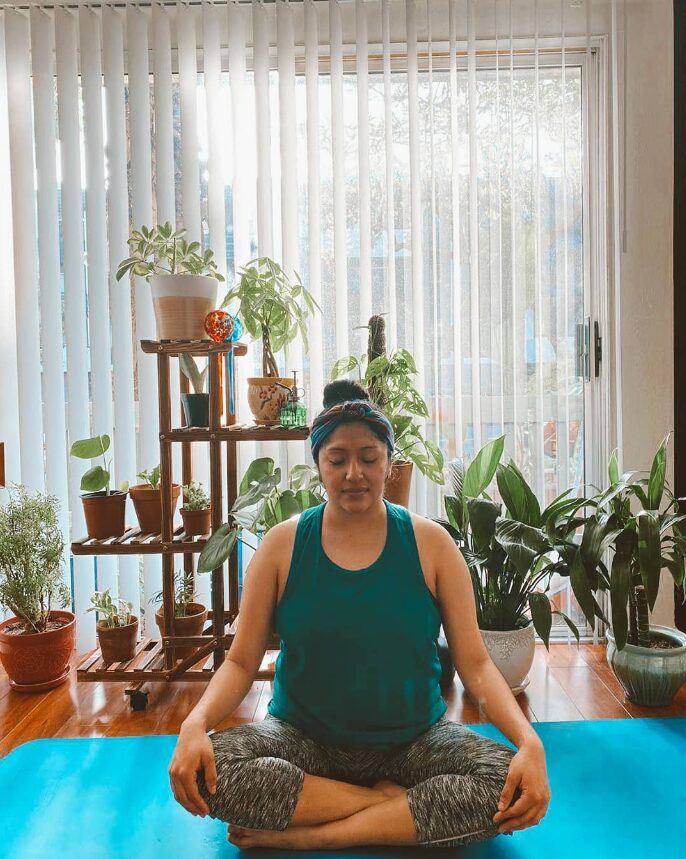 Woman yoga surrounded by plants