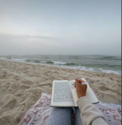 girl on beach journalling
